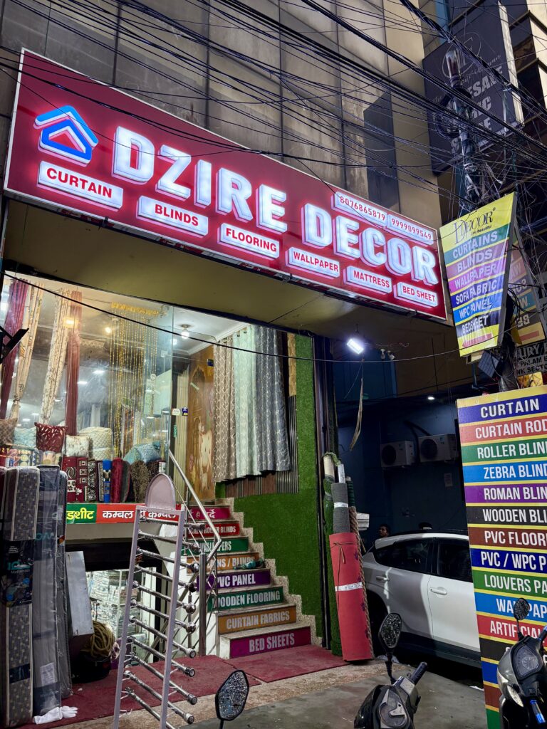 The exterior storefront of Dzire Decor, a home furnishing store showcasing premium blinds, curtains, wallpapers, and flooring.