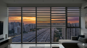 Motorized zebra blinds partially open on a floor-to-ceiling window in a modern Dwarka Expressway high-rise apartment during a city sunset.